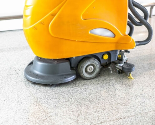 scrubbing the floor with floor cleaning machine