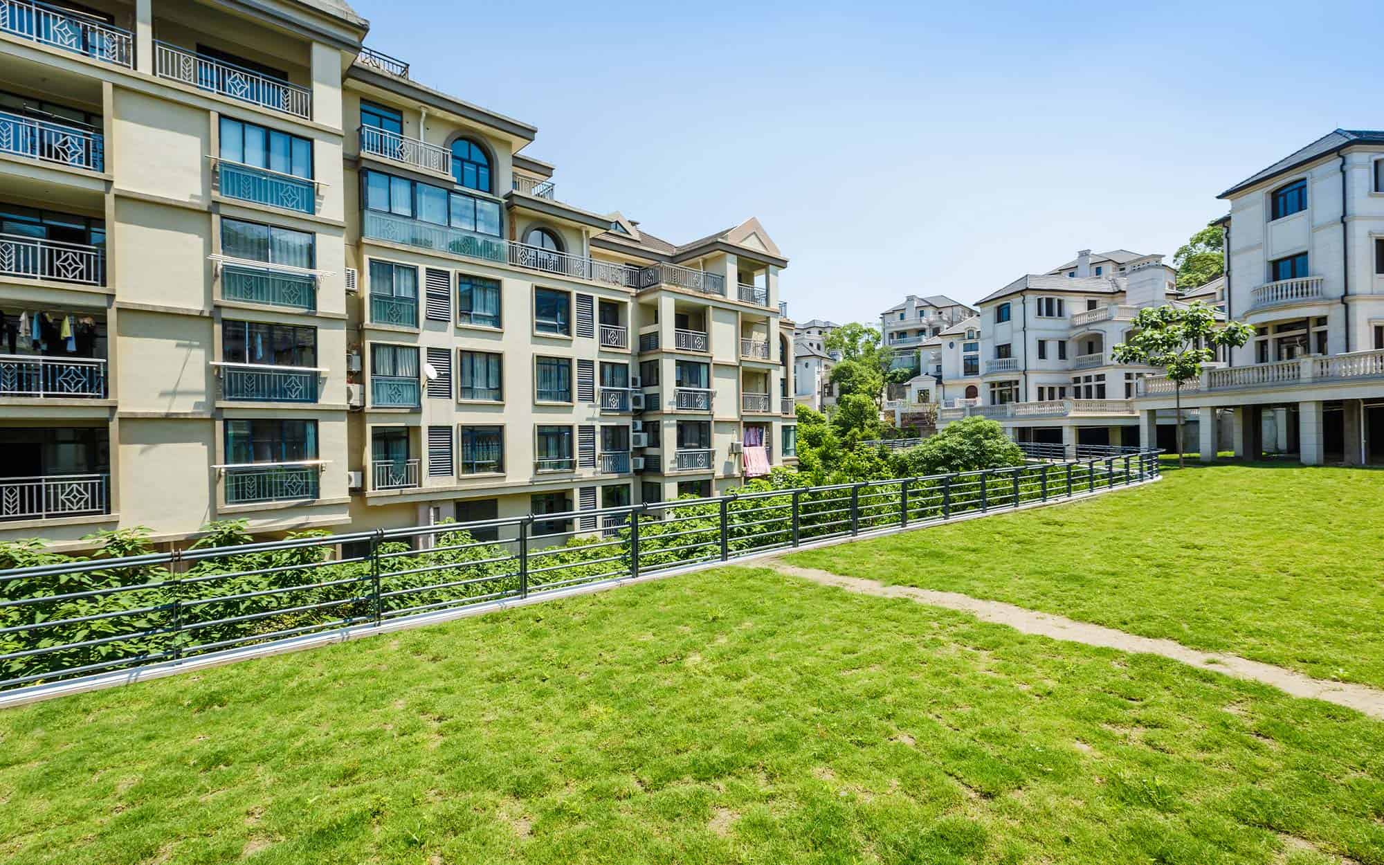 Row of condo appartments with a big green feild of grass in the front